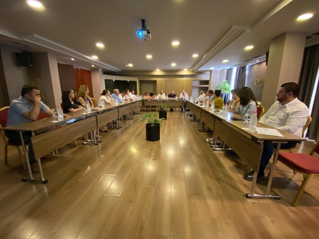 Takim i organizatës me pjesëmarrës rreth një tryeze diskutimi